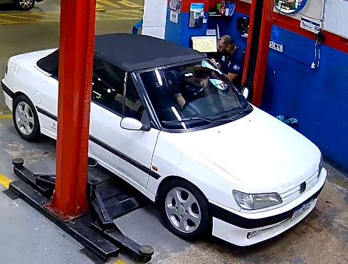 Peugeot clássico no elevador da oficina